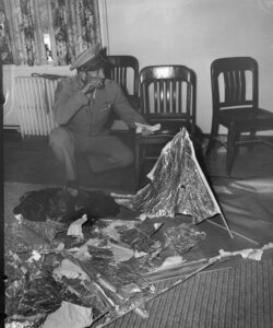 Brig. General Roger Ramey, holding telegram while inspects debris brought back from Roswell, NM, 07/08/1947